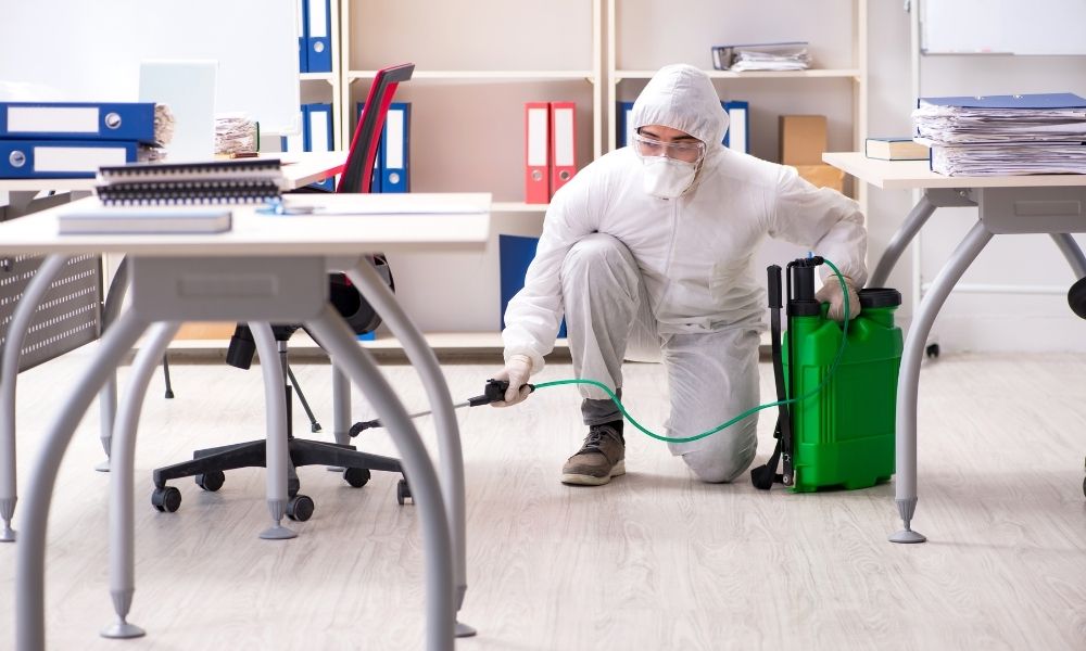 Técnico aplicando tratamiento de sanitización en una oficina corporativa