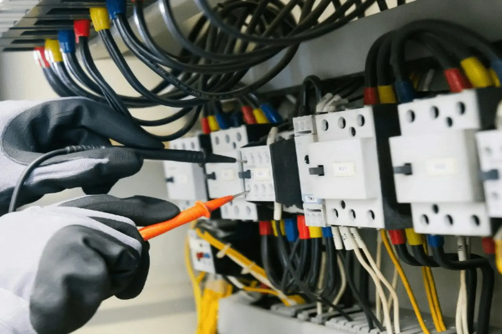 Técnico revisando con un multímetro el tablero eléctrico de un edificio